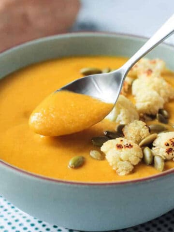 Spoonful of soup being lifted from the bowl.