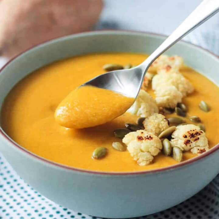 Spoonful of soup being lifted from the bowl.