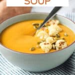 Bowl of sweet potato soup garnished with roasted cauliflower.