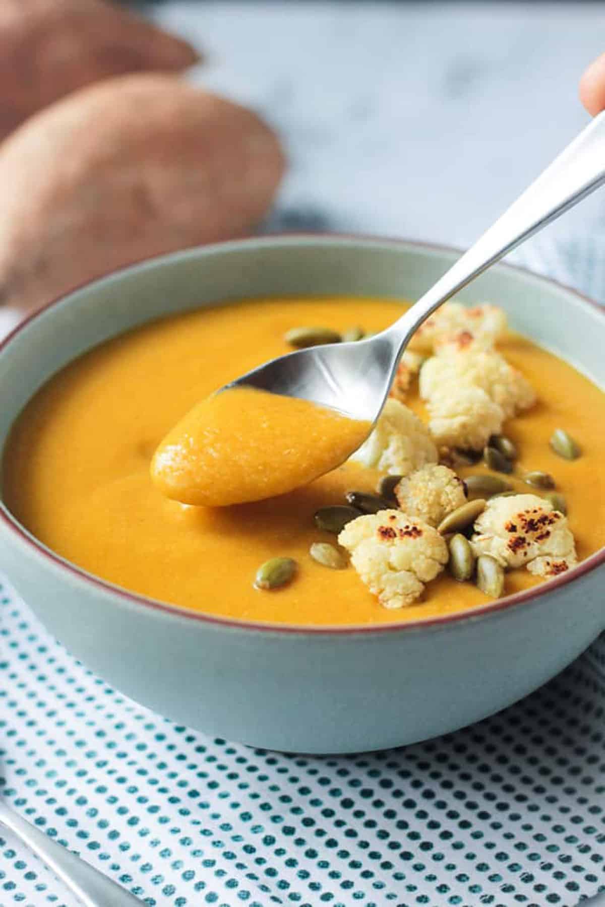 Spoonful of soup being lifted out of a bowl.