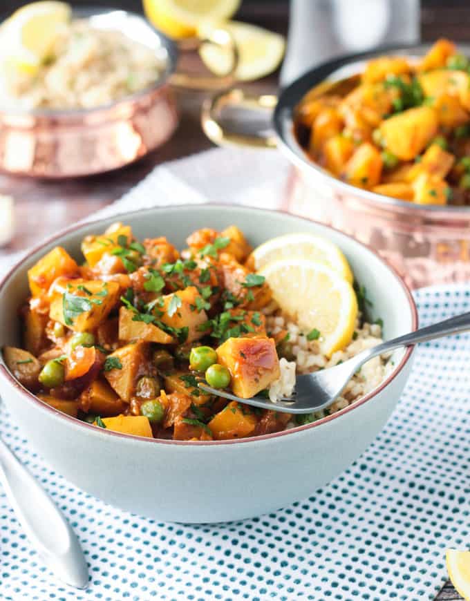 Forkful of potatoes and peas being lifted out of a bowl.