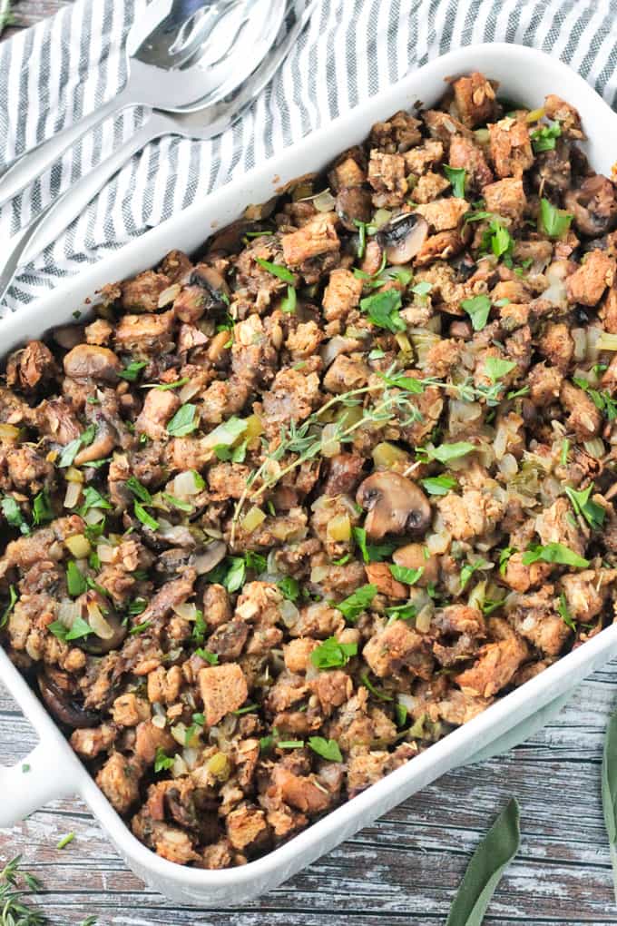 Pan of vegan stuffing with mushrooms. Fresh thyme sprigs lie on top.