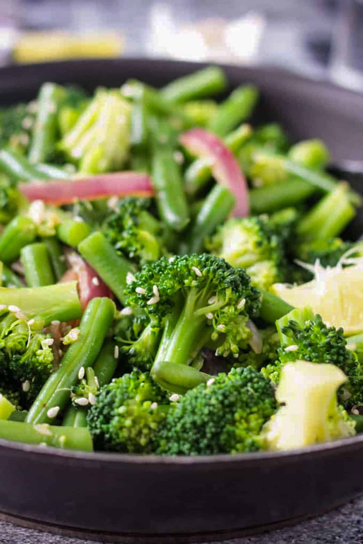 Easy Green Bean Broccoli Stir Fry. An easy weeknight vegetable side dish that takes less than 30 minutes. Just a few ingredients are needed, but it brings lots of flavor and nutrients. Serve it as a side or over pasta or rice. Close up of a broccoli floret in a stir fry.