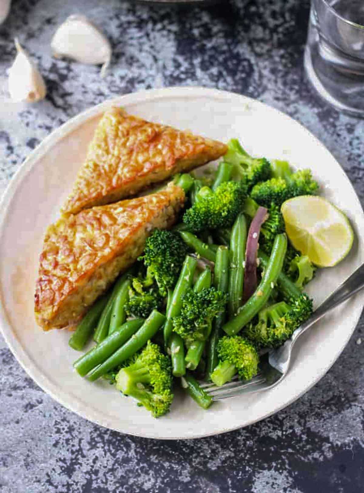 Easy Green Bean Broccoli Stir Fry. An easy weeknight vegetable side dish that takes less than 30 minutes. Just a few ingredients are needed, but it brings lots of flavor and nutrients. Serve it as a side or over pasta or rice. Plated final dish next to two triangles of tempeh.