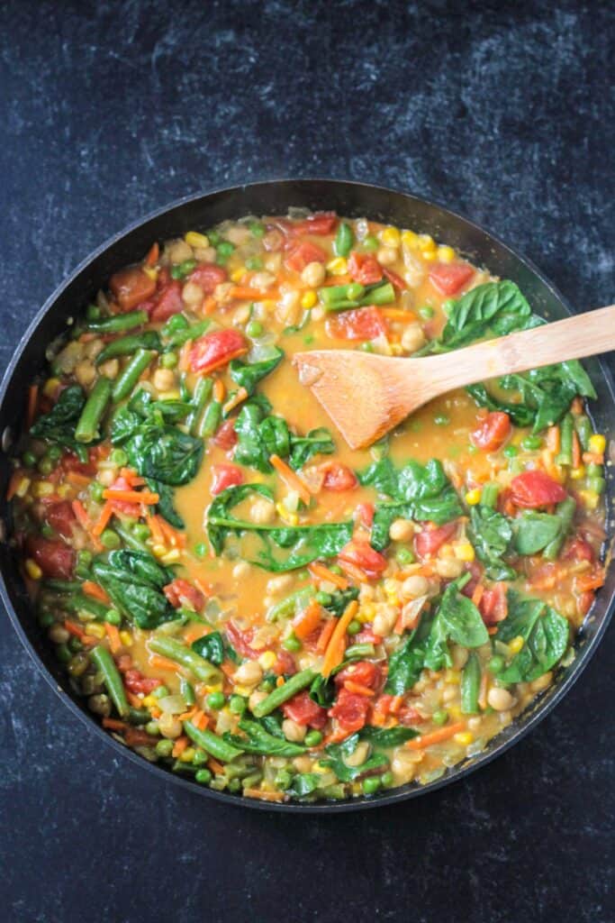 Spinach added to the saucy curry vegetable mixture.