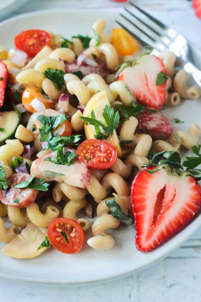 Close up overhead view of a plate of fresh vegetable summer pasta salad.