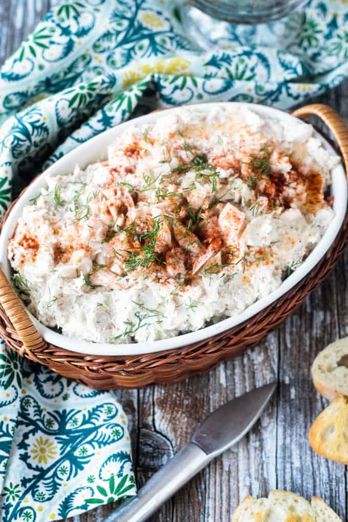 Close up of cold crab dip garnished with paprika and fresh dill.