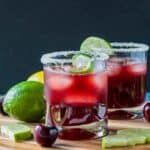 Three ice cubes floating in a glass of sparkling tart cherry lemonade.