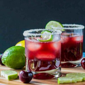 Three ice cubes floating in a glass of sparkling tart cherry lemonade.