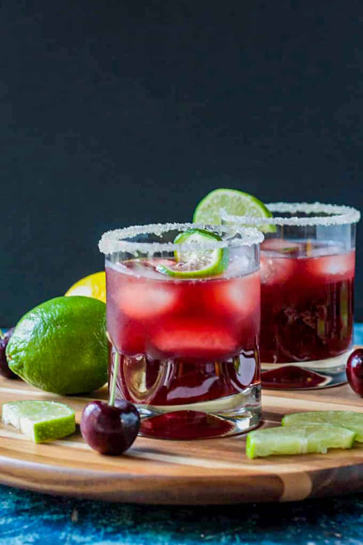 Three ice cubes floating in a glass of red juice drink.