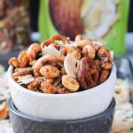 Close up front view of homemade trail mix in a white bowl stacked on top of a gray bowl.