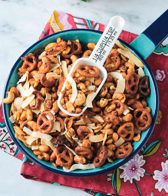 Large blue skillet of homemade trail mix with a white scoop on top.