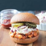 Vegan Chickpea BBQ Sandwich topped with creamy dairy free coleslaw and pickles on a whole wheat bun.