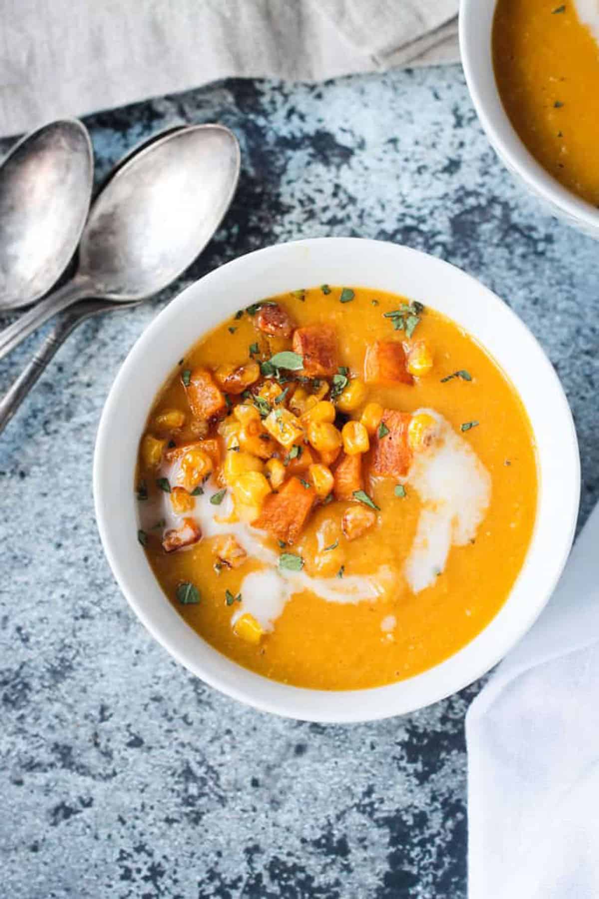 Vegan Butternut Squash Soup w/ Corn - incredibly flavorful with simple ingredients, this cozy soup will have you coming back for seconds. Silky smooth creamy soup base with no absolutely no dairy. Perfect for lunch or dinner. Even my kids loved this! Bowl of butternut squash corn soup with diced roasted squash and corn kernels.