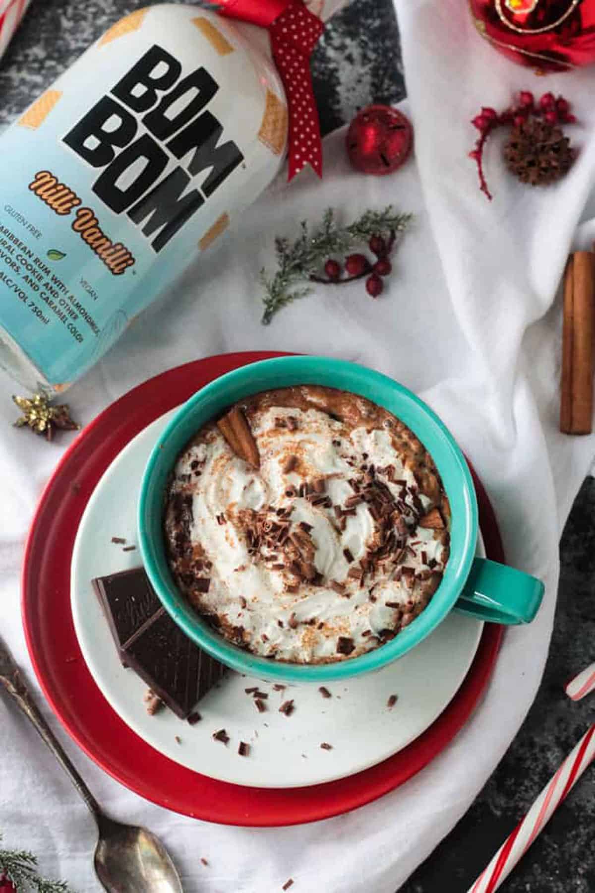 Bom Bom Brands Nilli Vanilli bottle near a mug of spiked vegan hot cocoa.