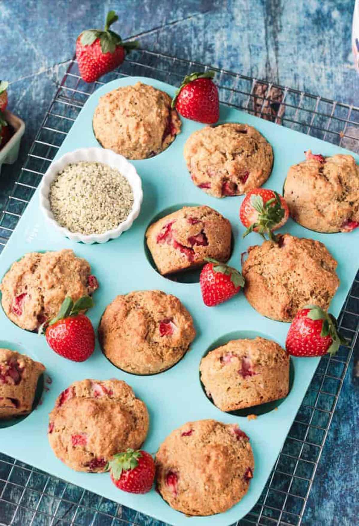 Protein muffins with strawberries in a blue silicone muffin pan.