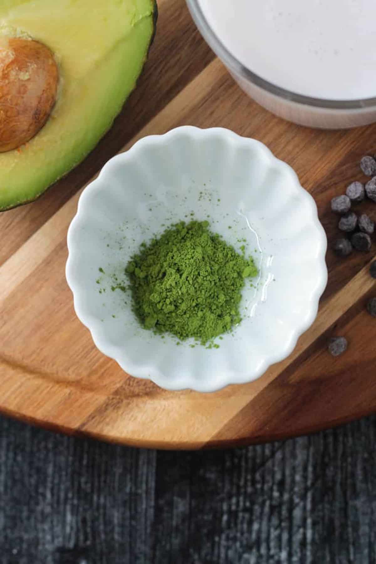Close up of a matcha green tea powder in a white bowl.