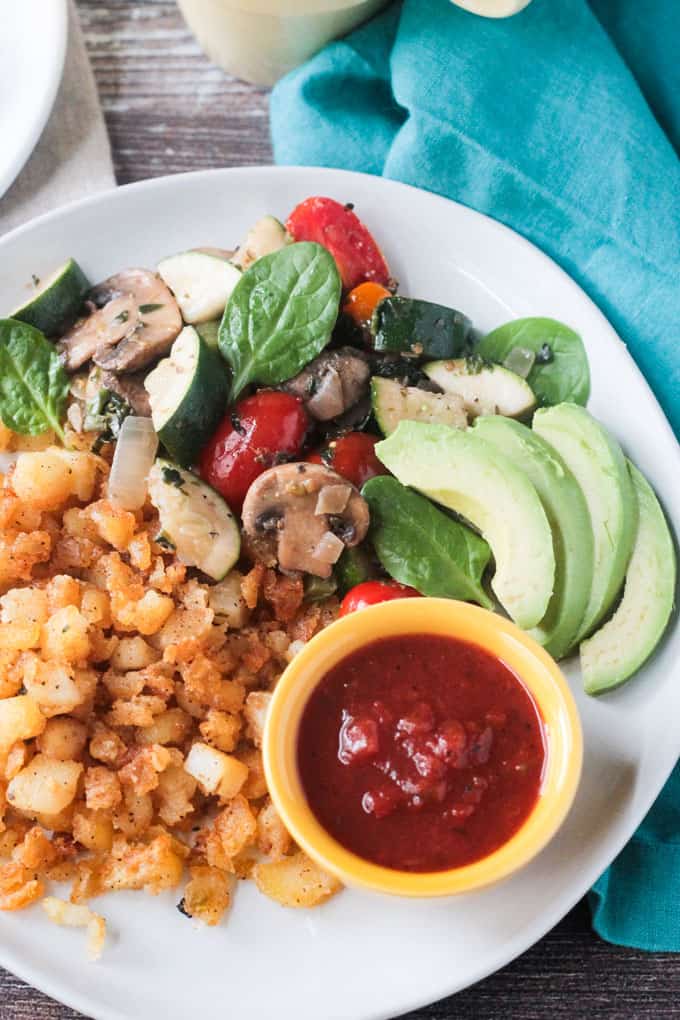 Breakfast hash browns, skillet veggies, avocado, and salsa.