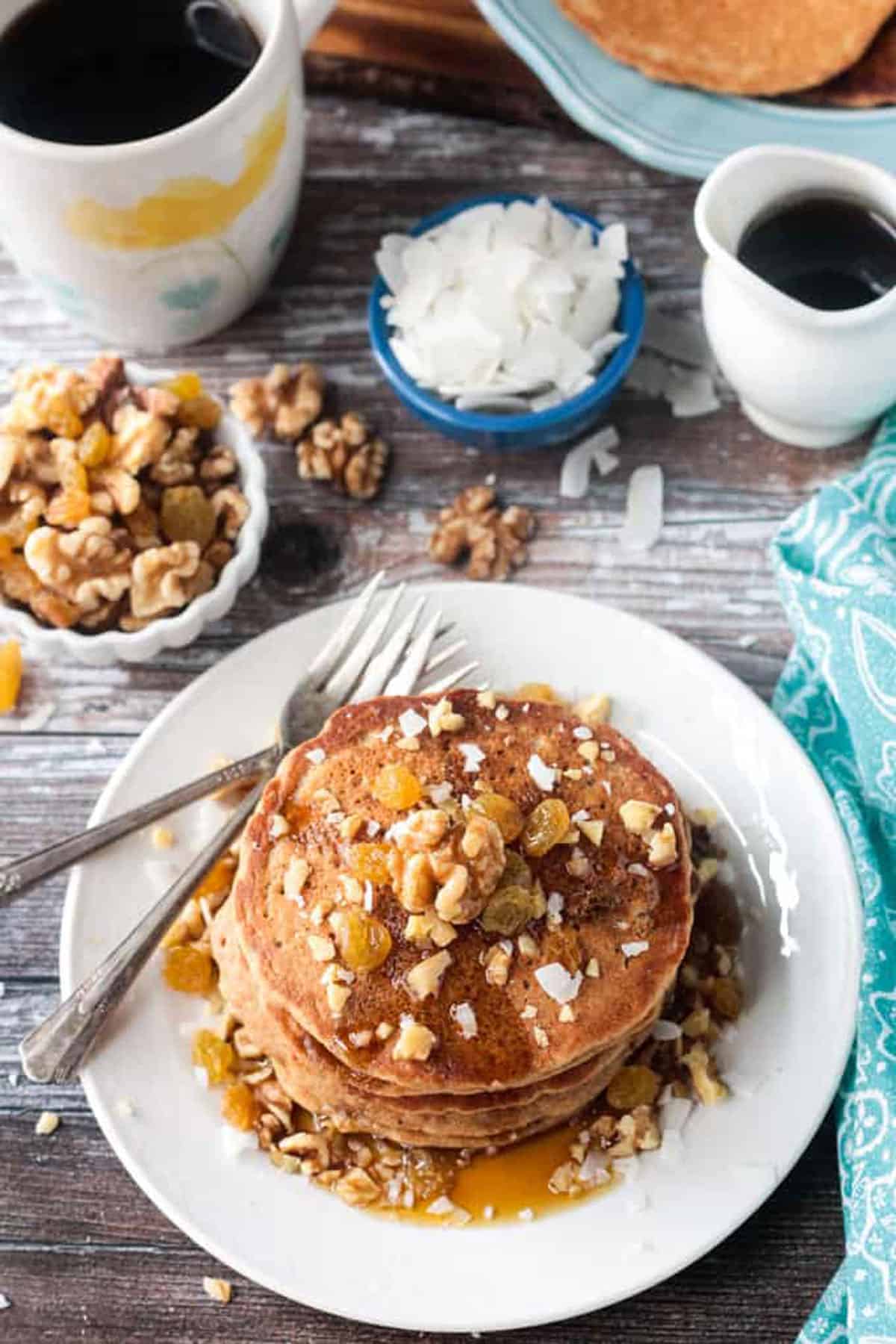 Overhead view of a stack of pancakes on a plate with two forks.