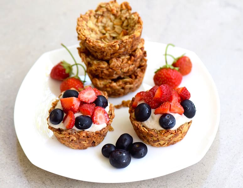 granola cups topped with cream and fresh fruit