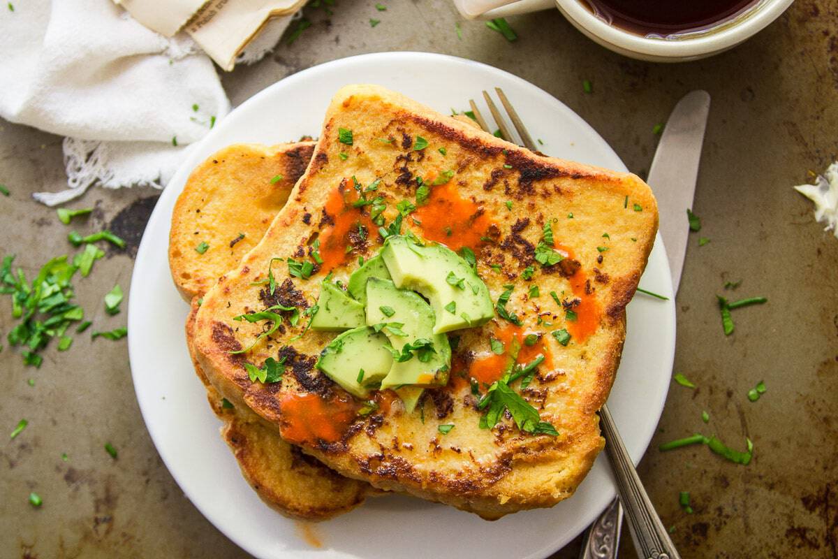 savory french toast on a plate topped with avocado