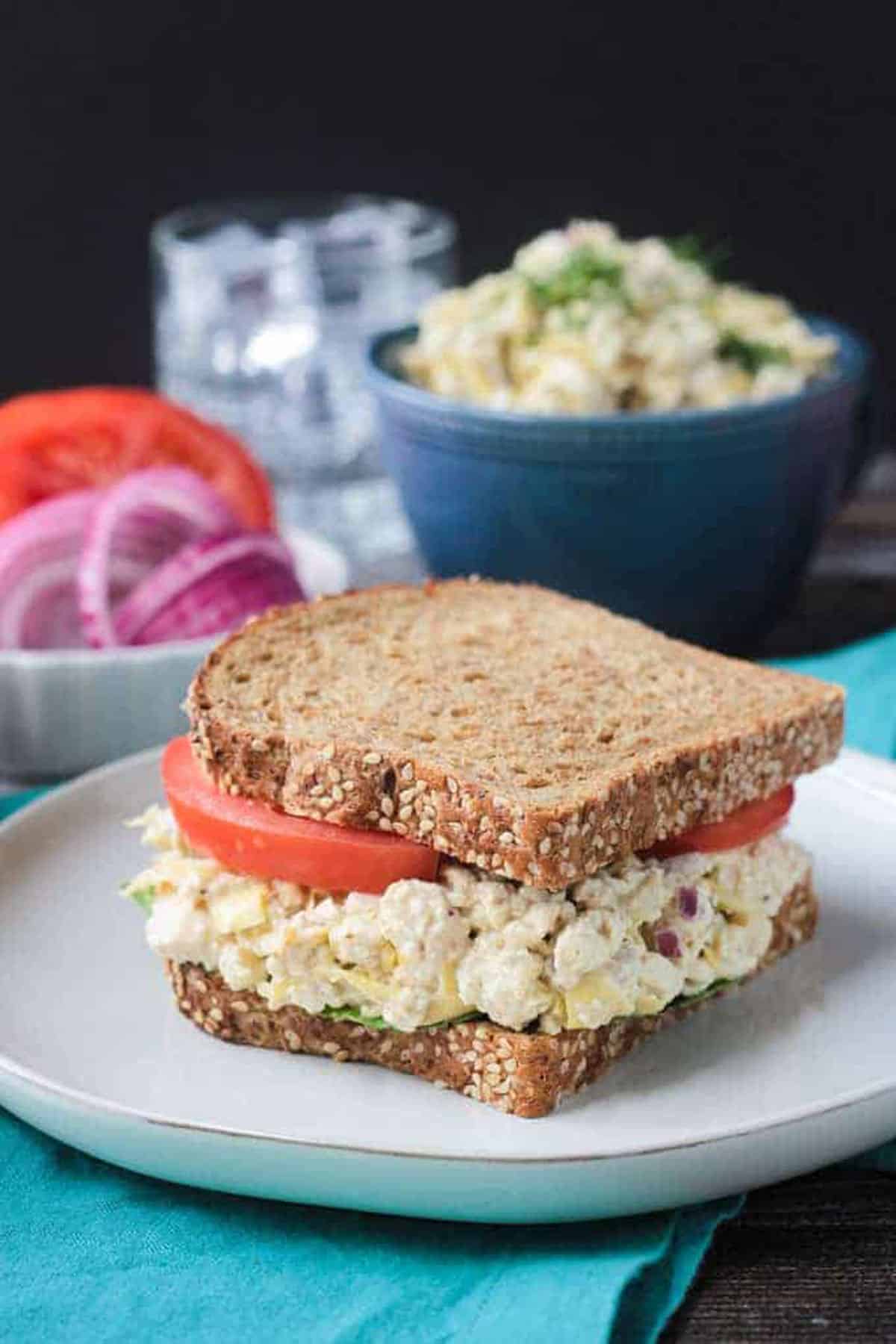 Vegan Tun Salad Sandwich on whole grain bread with tomato slices. 