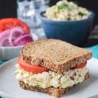 Vegan Tun Salad Sandwich on whole grain bread with tomato slices.