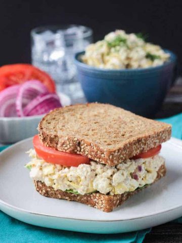 Vegan Tun Salad Sandwich on whole grain bread with tomato slices.