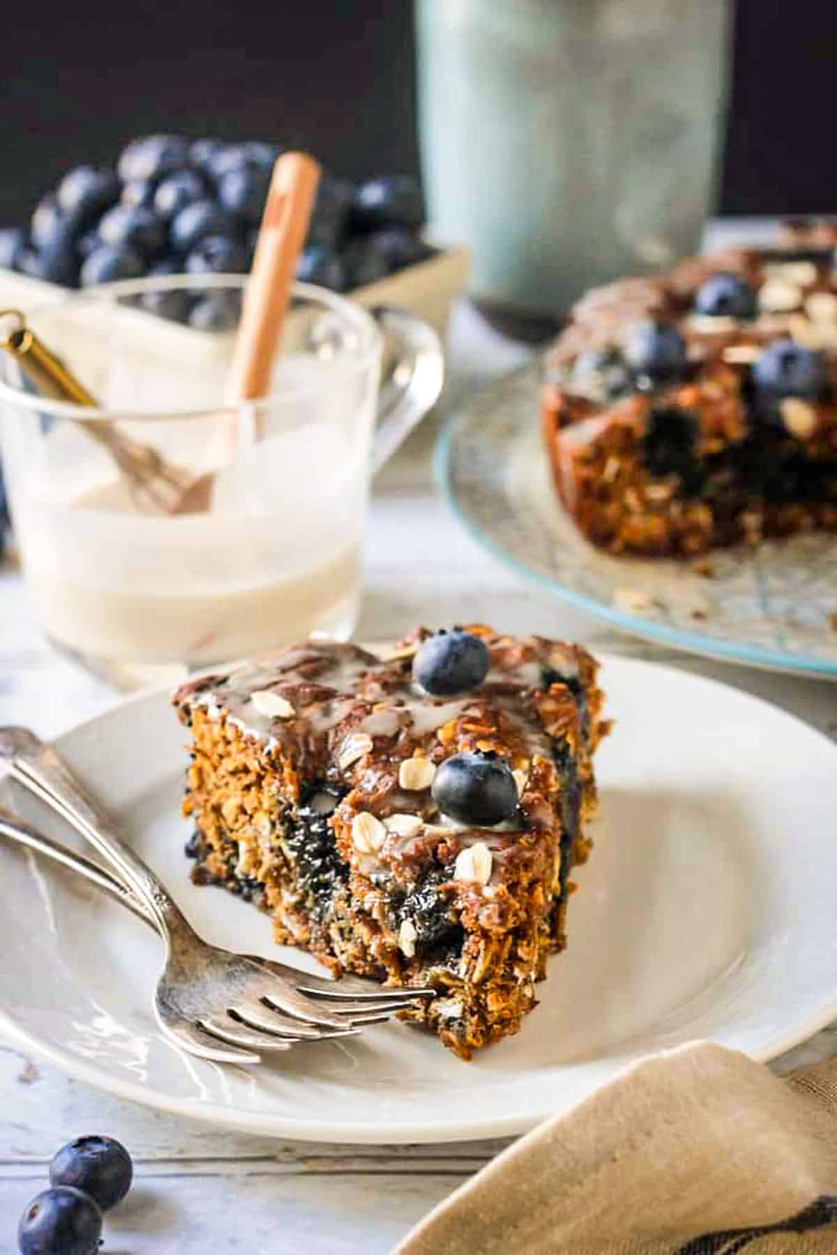 Slice of blueberry breakfast cake on a plate with two forks.