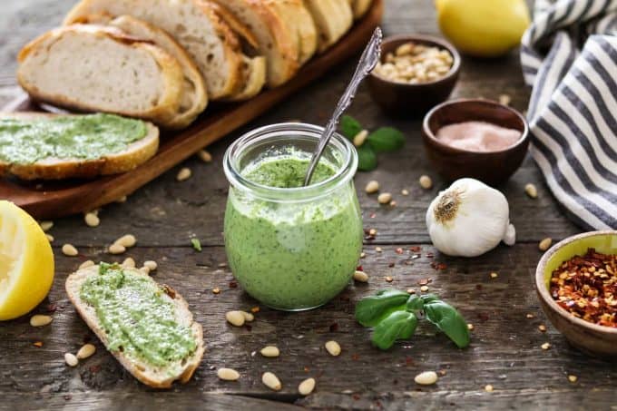pesto in a small glass jar with a spoon