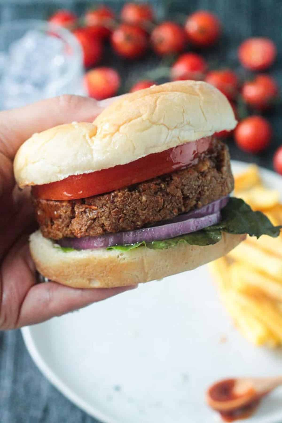 Hand holding a veggie burger.