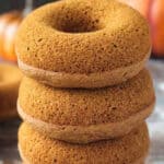 Stack of 4 unfrosted baked vegan pumpkin donuts.