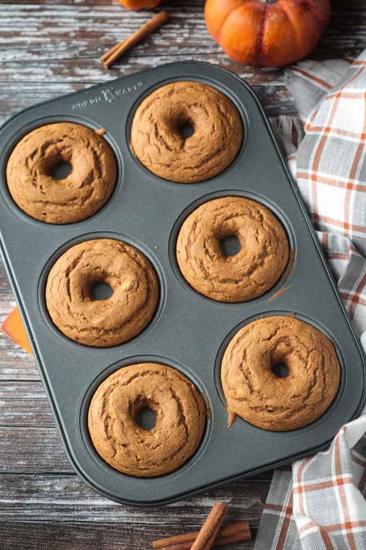 Donut pan with 6 baked donuts fresh from the oven.