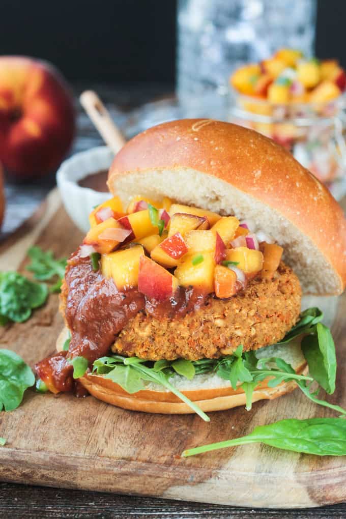 Veggie burger topped with drippy bbq sauce and fresh peach salsa on a bun