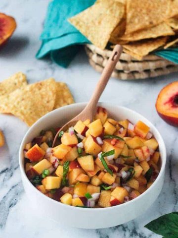 Flecks of chiffonade basil garnished on top of a fresh peach salsa recipe