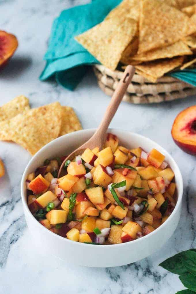 Flecks of chiffonade basil garnished on top of a fresh peach salsa recipe