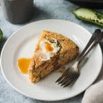 One slice of vegan jalapeño cornbread topped with butter and maple syrup.