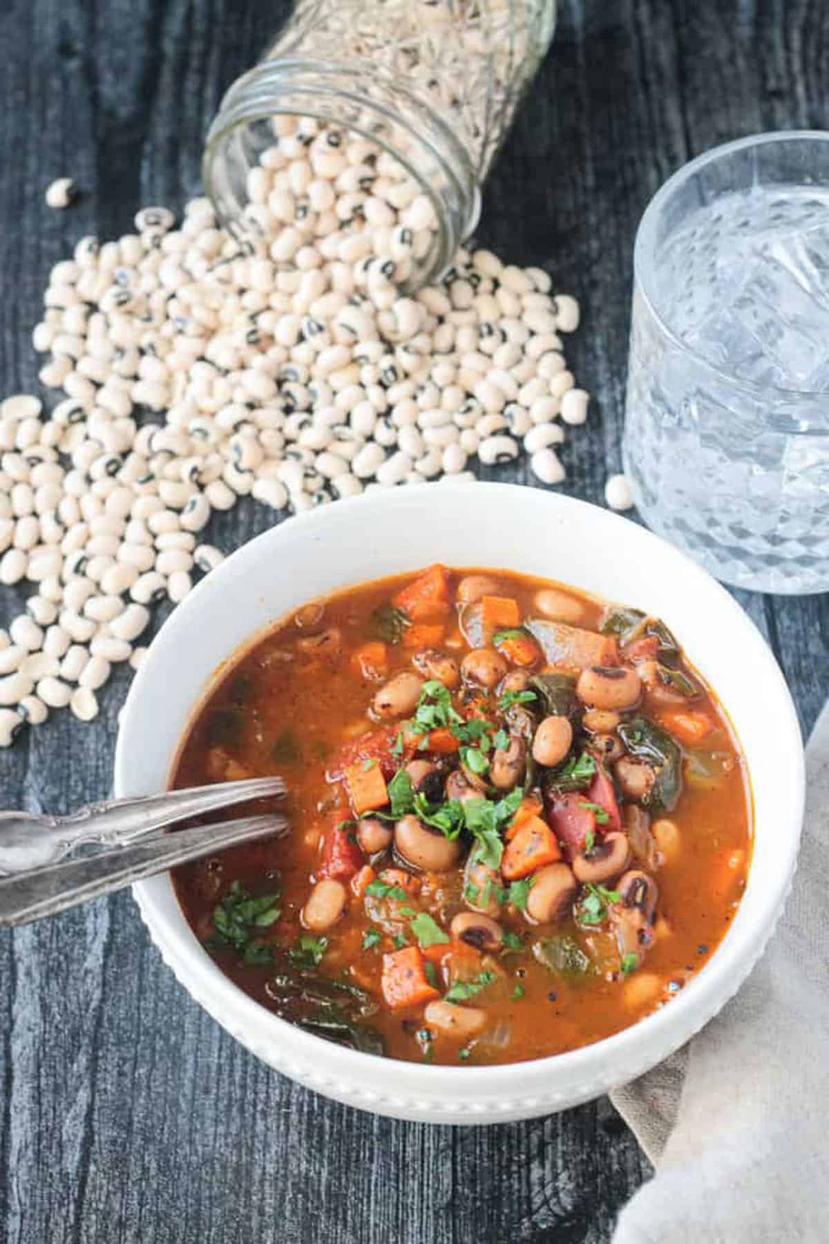 Two spoons in a bowl of Black Eyed Pea Soup.