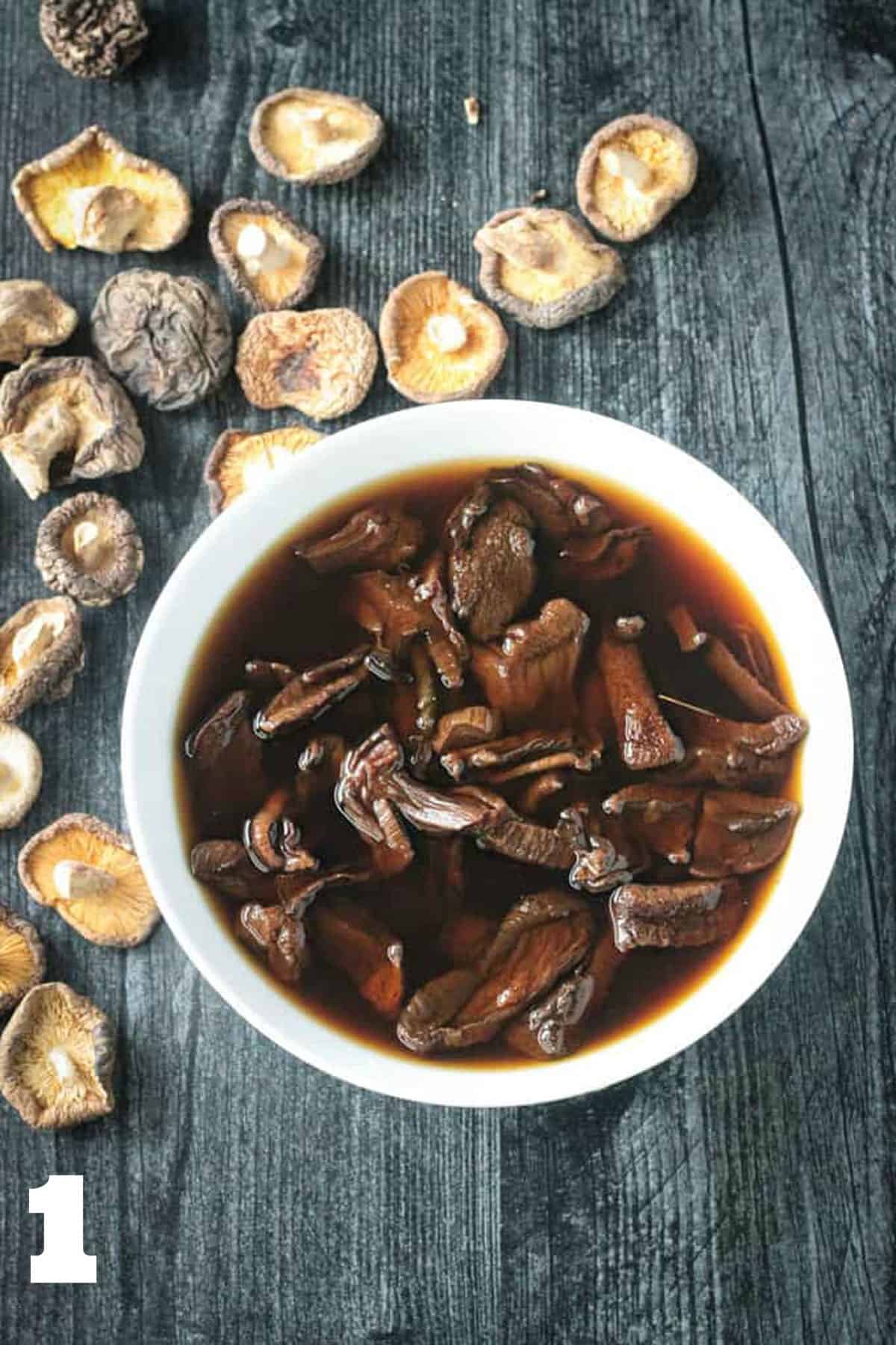 Dried porcini mushrooms soaking in water in a bowl.