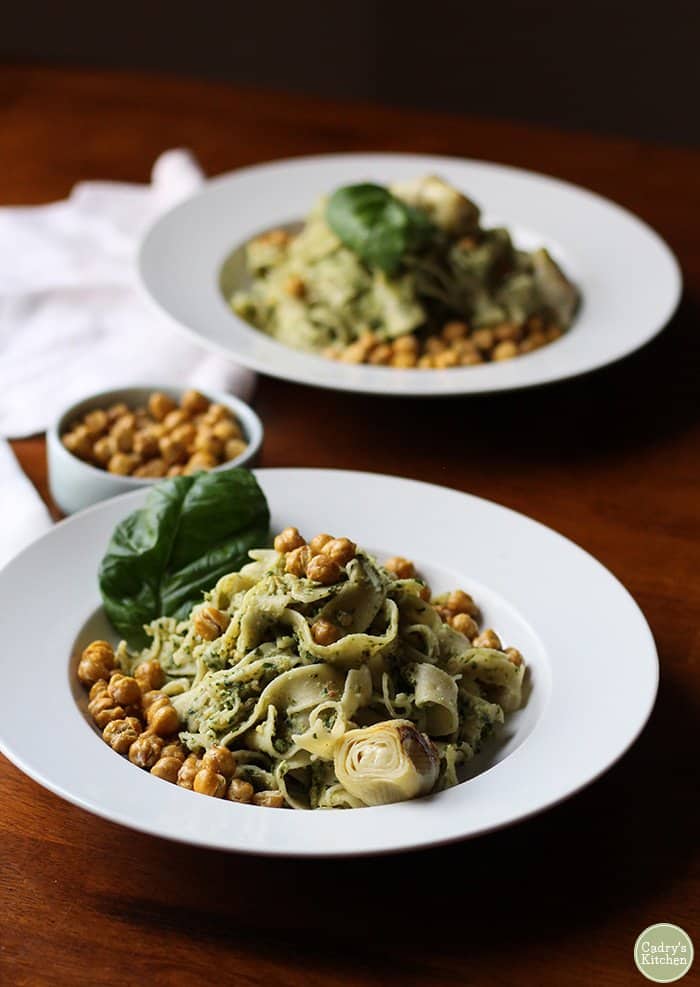 two plates of pasta with chickpeas and artichokes