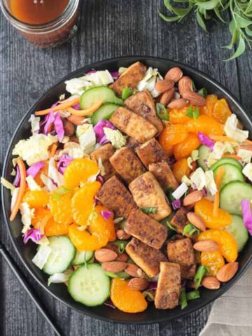 Salad w/ green and red cabbage, cucumbers, mandarin oranges, carrots, and baked tofu.