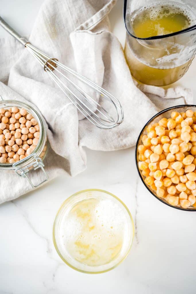 bowl of chickpeas next to a bowl of aquafaba