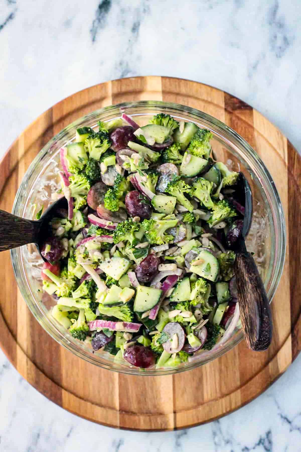 Tahini Broccoli Salad in a mixing bowl with salad tongs.