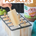 One apple popsicles being lifted from a mold.