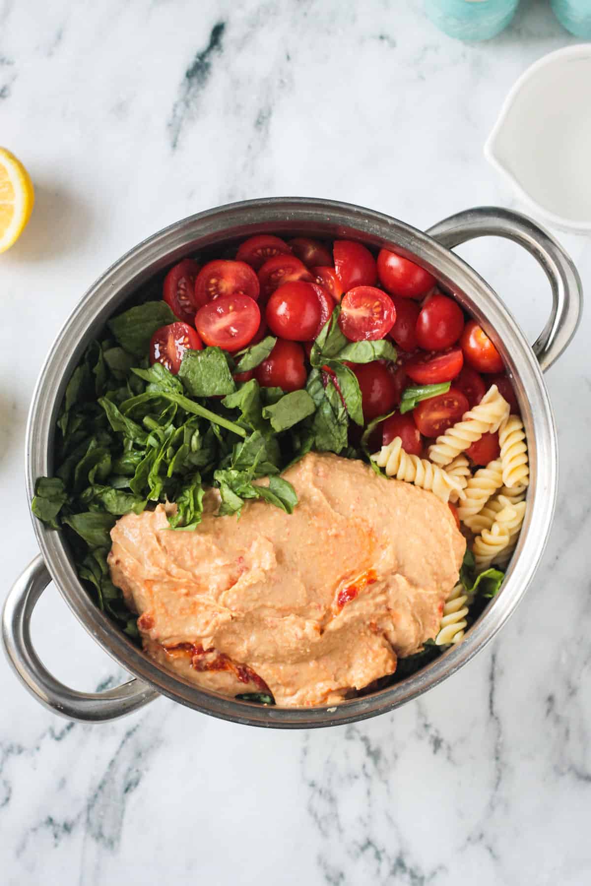Chopped spinach, grape tomatoes, and hummus added to the pasta.