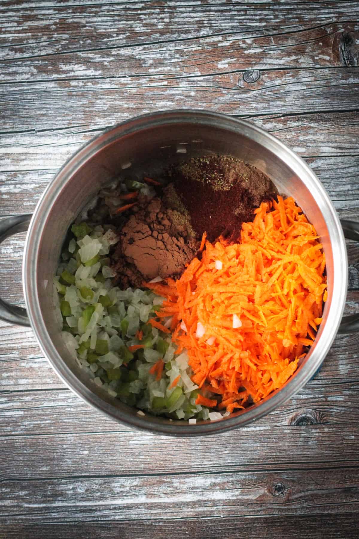 Adding spices and shredded carrots to the pot.