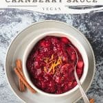 A bowl of cranberry sauce topped with fresh orange zest.