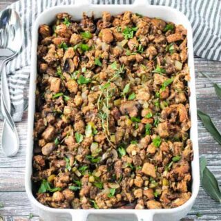 Finished dish of vegan stuffing with mushrooms in a white baking dish.