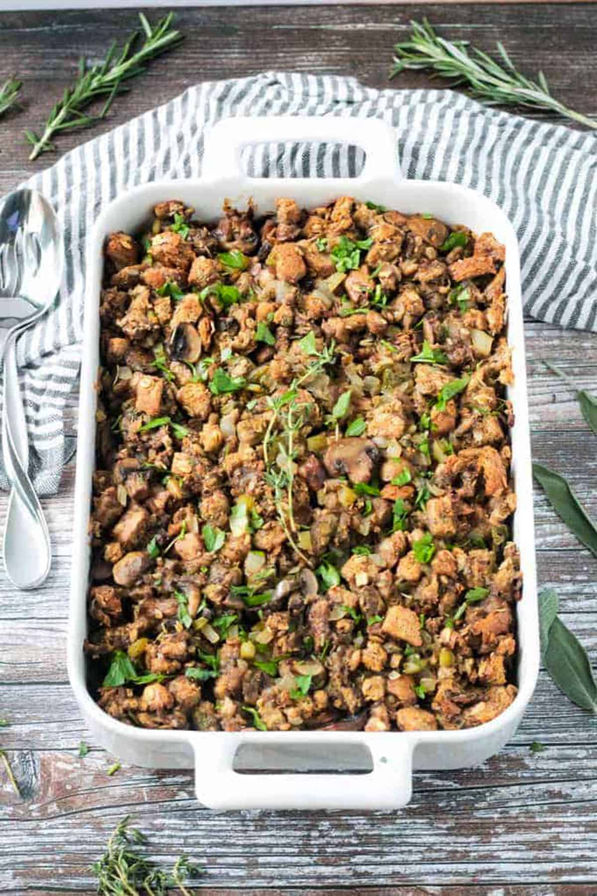 Finished dish of vegan stuffing with mushrooms in a white baking dish.