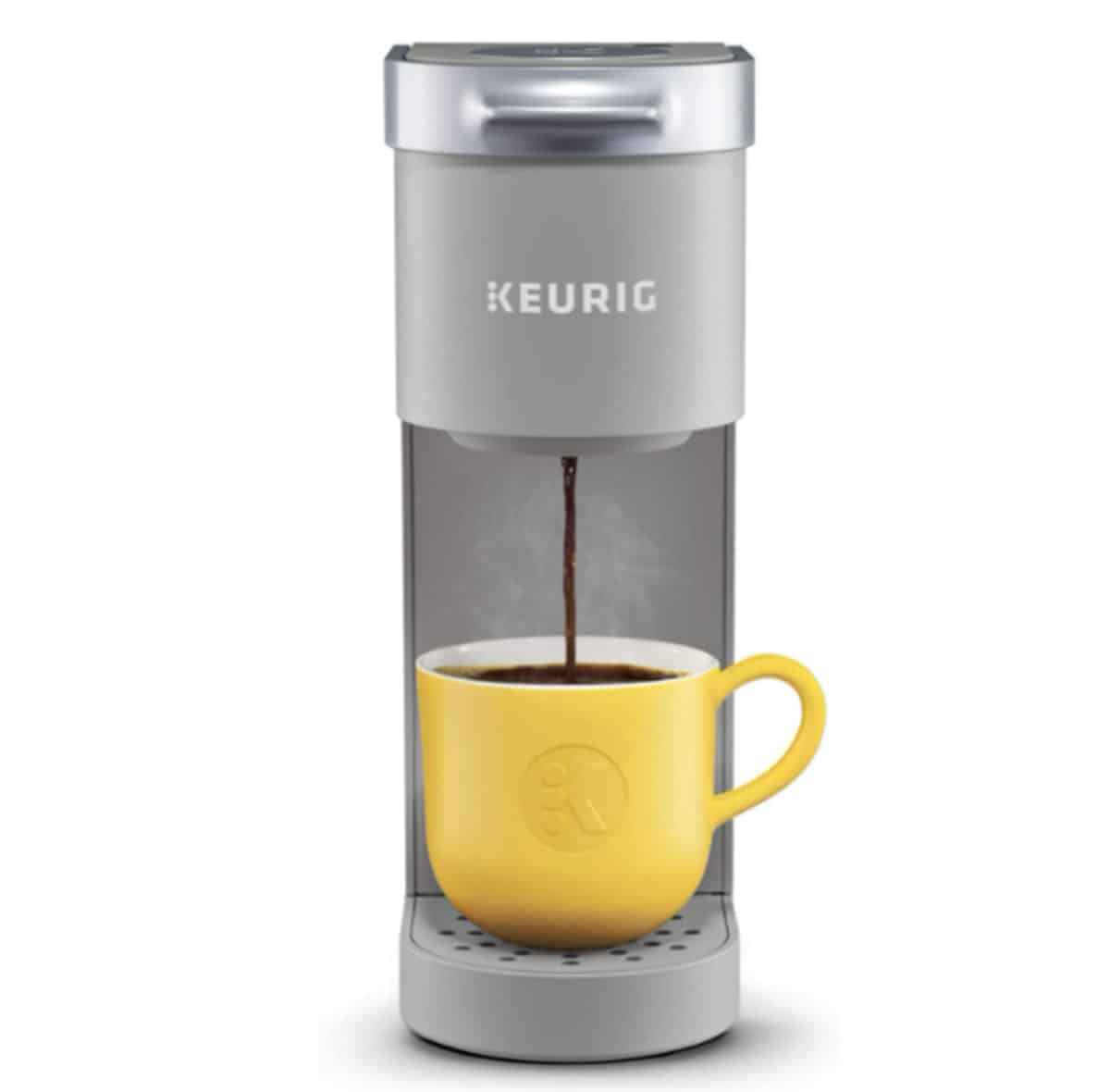 Gray Keurig single serve coffee maker with yellow coffee mug.